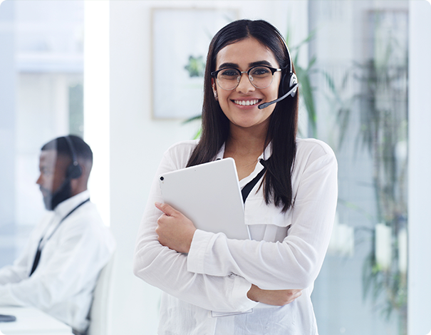 Professional Excellence Billing customer representative wearing a headset and holding a tablet in a modern office, ready to assist healthcare providers.